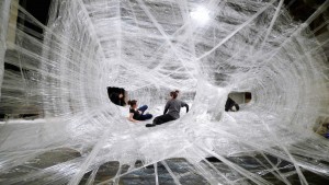 personas interactuando en instalacion tela de araña