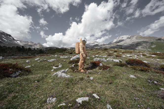 astronauta en madera que admira las vistas a su alrededor en las dolomitas
