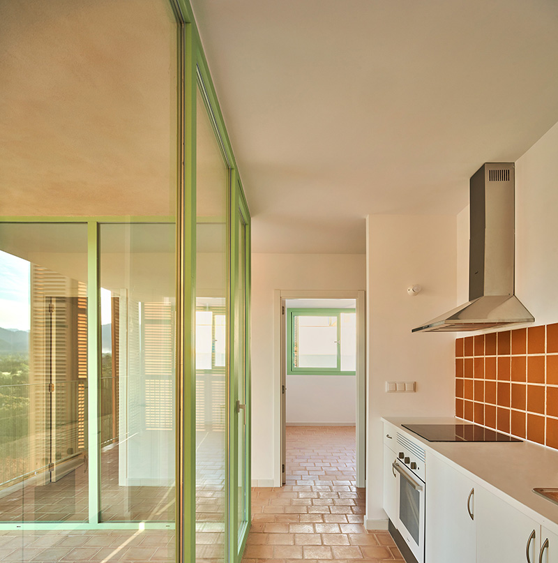 Vista interior con cocina y carpinterias en verde del Proyecto en INCA de Alventosa Morell Arquitectes VPO en despiertaymira