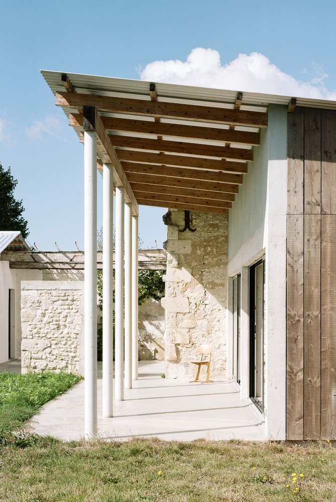 Vista lateral del porche en la transformación de un granero en una casa de vacaciones en Francia de Migeon Architecture. 