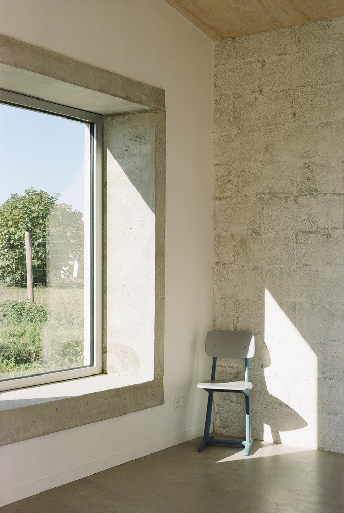 Detalle de marco interior de hormigón en ventana grande en la transformación de un granero en una casa de vacaciones en Francia de Migeon Architecture. 