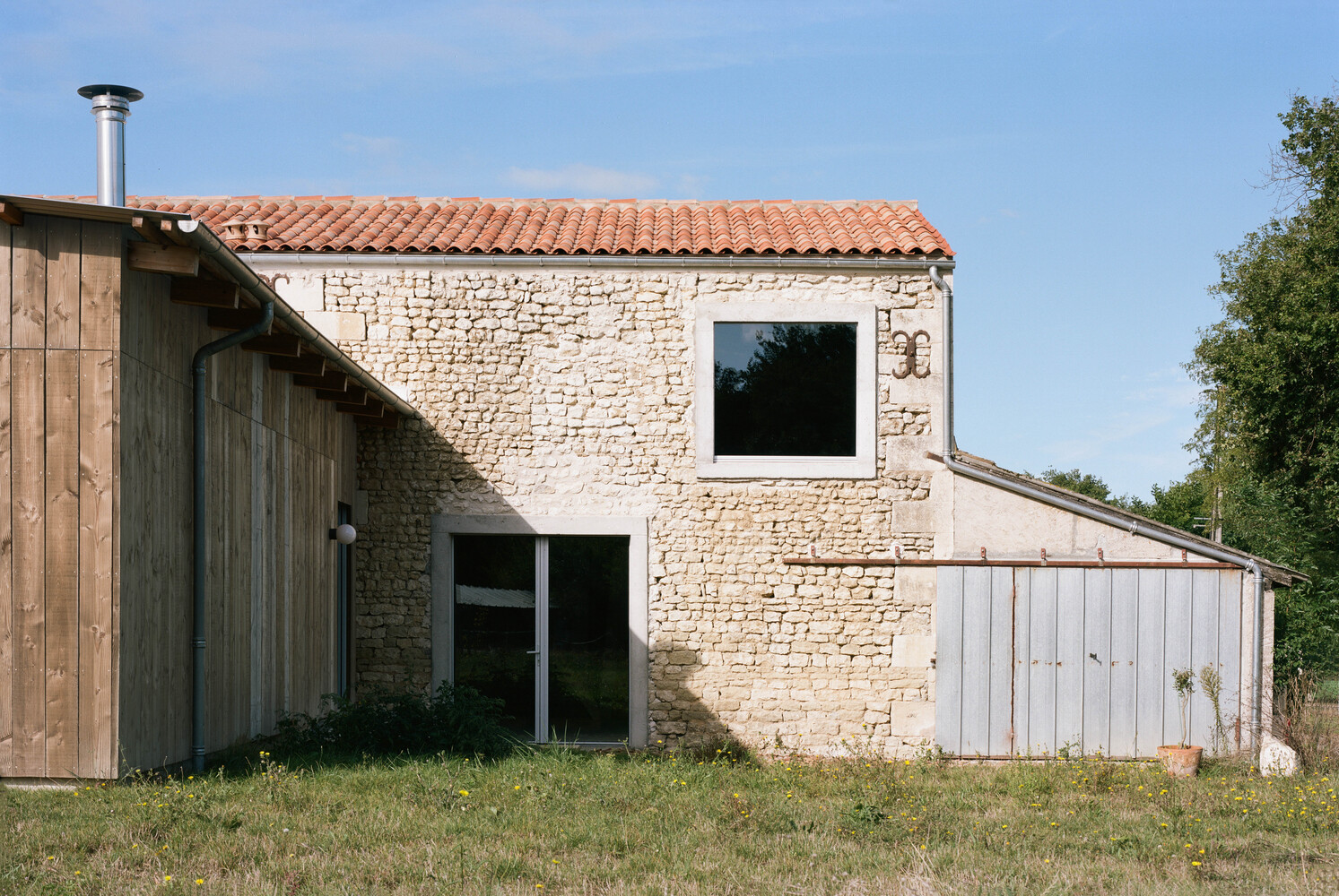 Lateral del edificio principal de la transformación de un granero en una casa de vacaciones en Francia de Migeon Architecture. 