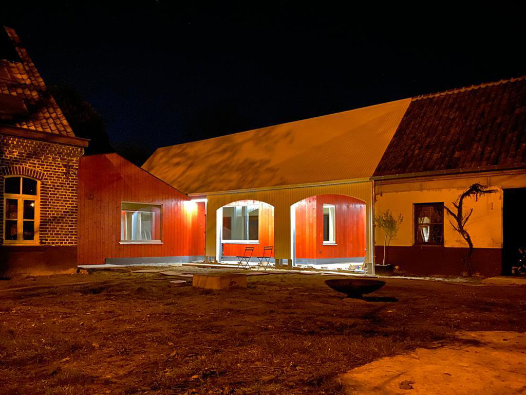 Foto nocturna de la parte nueva del antiguo granero en Gijzenzele rehabilitado por Atelier Tom Vanhee